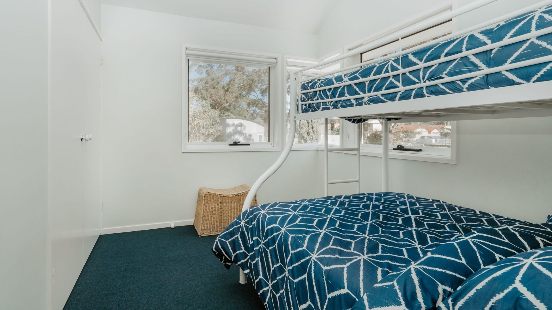 Habitación con literas y vistas a árboles por la ventana.
