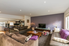 A modern living room with a sofa, coffee table, and a television.