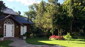Ein Haus mit einem gepflasterten Weg zum Eingang, umgeben von einem gepflegten Rasen und blühenden Pflanzen.