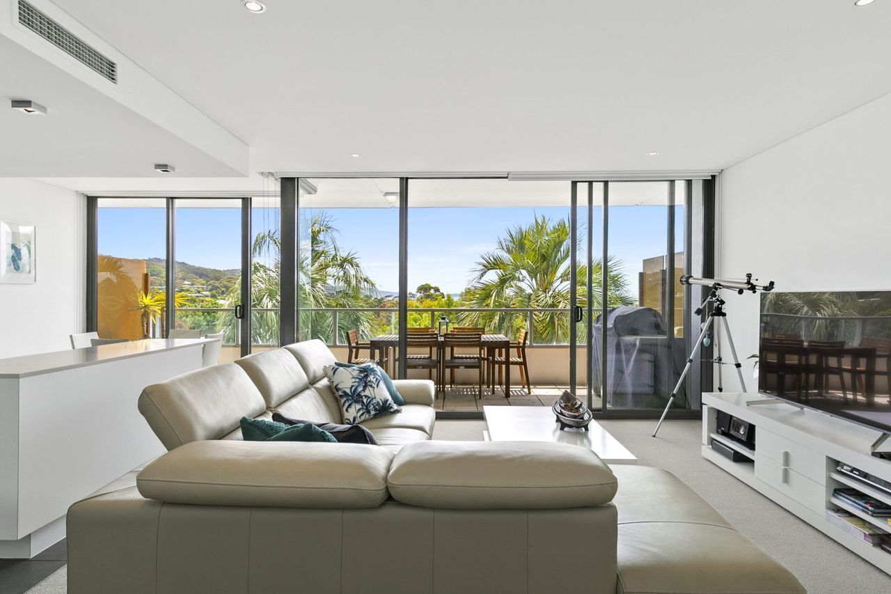 Ein modernes Wohnzimmer mit Sofa, Essbereich und einem Balkon mit Blick.
