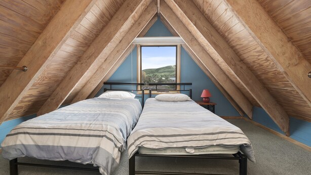 Une chambre avec deux lits, une fenêtre et une vue sur l’extérieur.