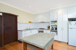 A modern kitchen with white cabinets, a granite countertop, and stainless steel appliances. - Callahan (Marengo)