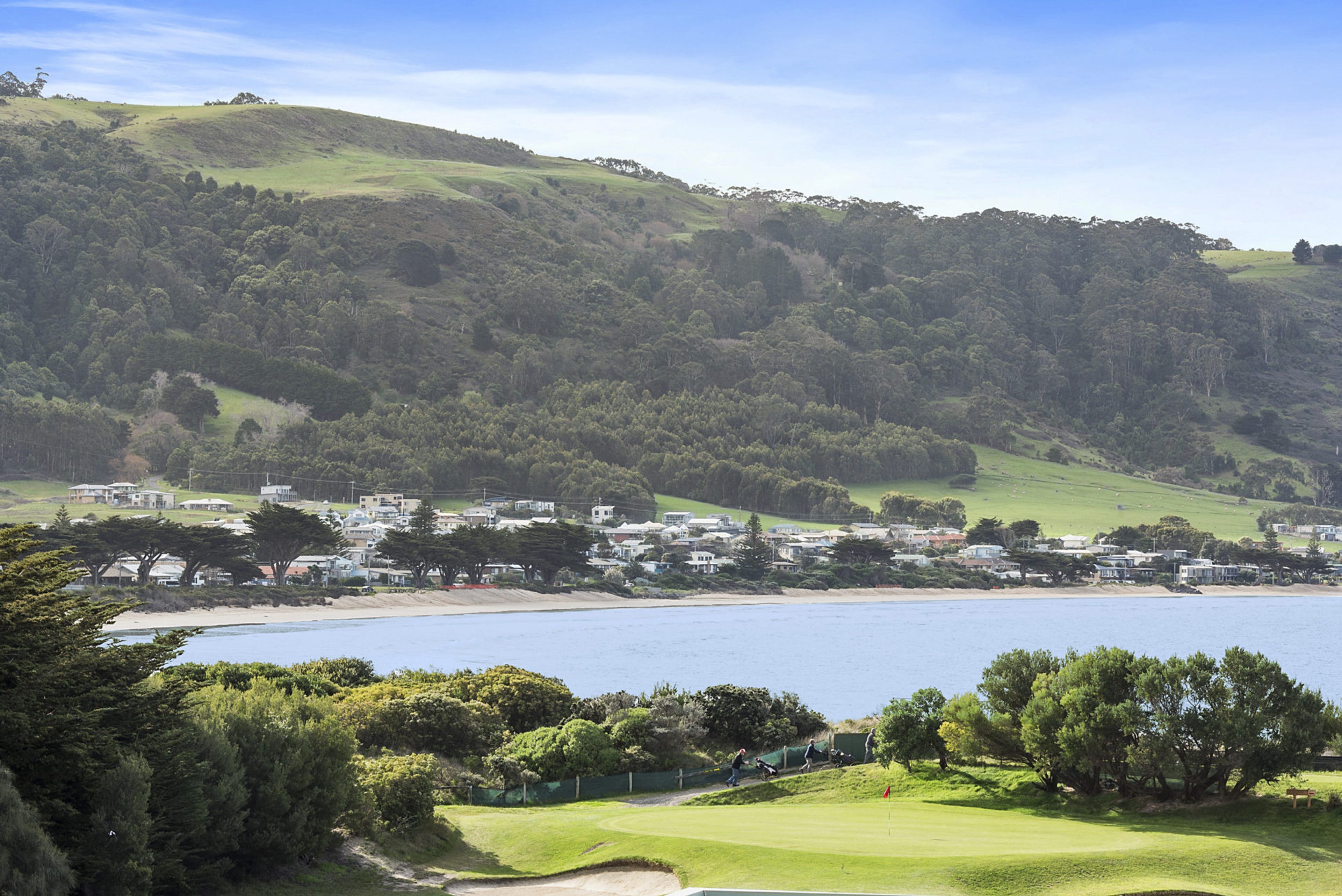 Une ville côtière dotée d’un parcours de golf, de bâtiments résidentiels et bordée de collines.