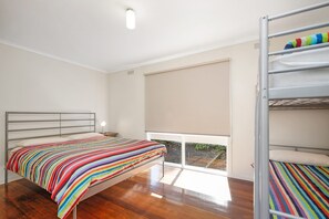 A bedroom with a bed, a window, and a bunk bed. - Beach Fig (Skenes Creek, Apollo Bay)
