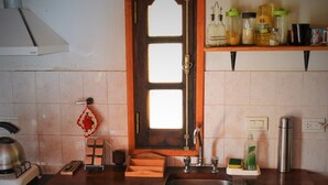 A kitchen with a wooden countertop, a sink, a stove, and a window above the sink. - Cabañas San Gabriel Arcangel (Capilla del Monte)