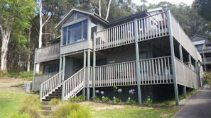 A two-story building with a balcony, a staircase, and a sign indicating a car garage. - Carrageen (Lorne)