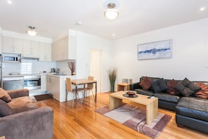 Un apartament modern amb cuina, menjador i saló.