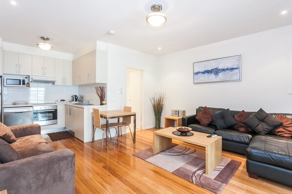 A modern apartment with a kitchen, dining area, and living room. - Anglesea River Apartment 23 (Anglesea)