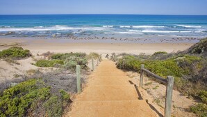 A sandy beach with a wooden pathway leading to the ocean. - Anglesea River Apartment 23 (Anglesea)