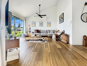 A modern living room with a sofa, coffee table, and a view of the outdoors. - SeaEsta - Modern Beachside Escape North Lorne (Lorne)