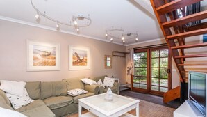 A living room with a sofa, coffee table, and artwork on the wall.