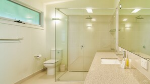 A modern bathroom with a glass-enclosed shower, a toilet, and a sink with a mirror. - Ocean Magic - Where The Bush Greets The Sea (Wye River)