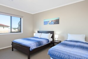 A hotel room with two beds, a large window, and a painting on the wall. - Albion (Apollo Bay)