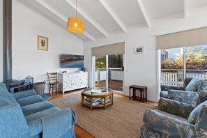Ein geräumiges Wohnzimmer mit großem Fenster, Kamin und einer gemütlichen Sitzecke.