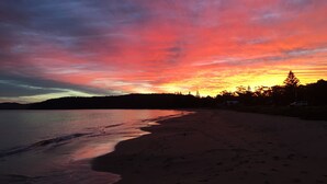 A beach with a sunset sky.