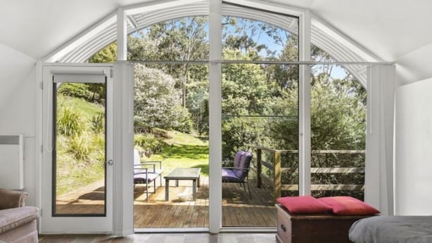 A room with a sliding glass door leading to an outdoor patio with a table and chairs.