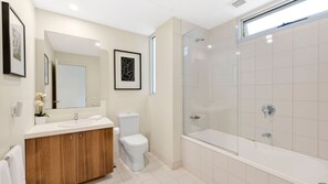 Une salle de bain moderne avec un meuble-lavabo, des toilettes et une douche à l’italienne.
