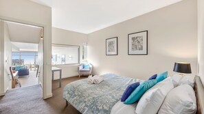 Une chambre d’hôtel avec un lit, un bureau, une chaise et une vue sur la ville.