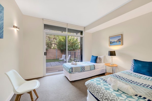 Une chambre à coucher avec un lit, une chaise, une table et un tableau accroché au mur.