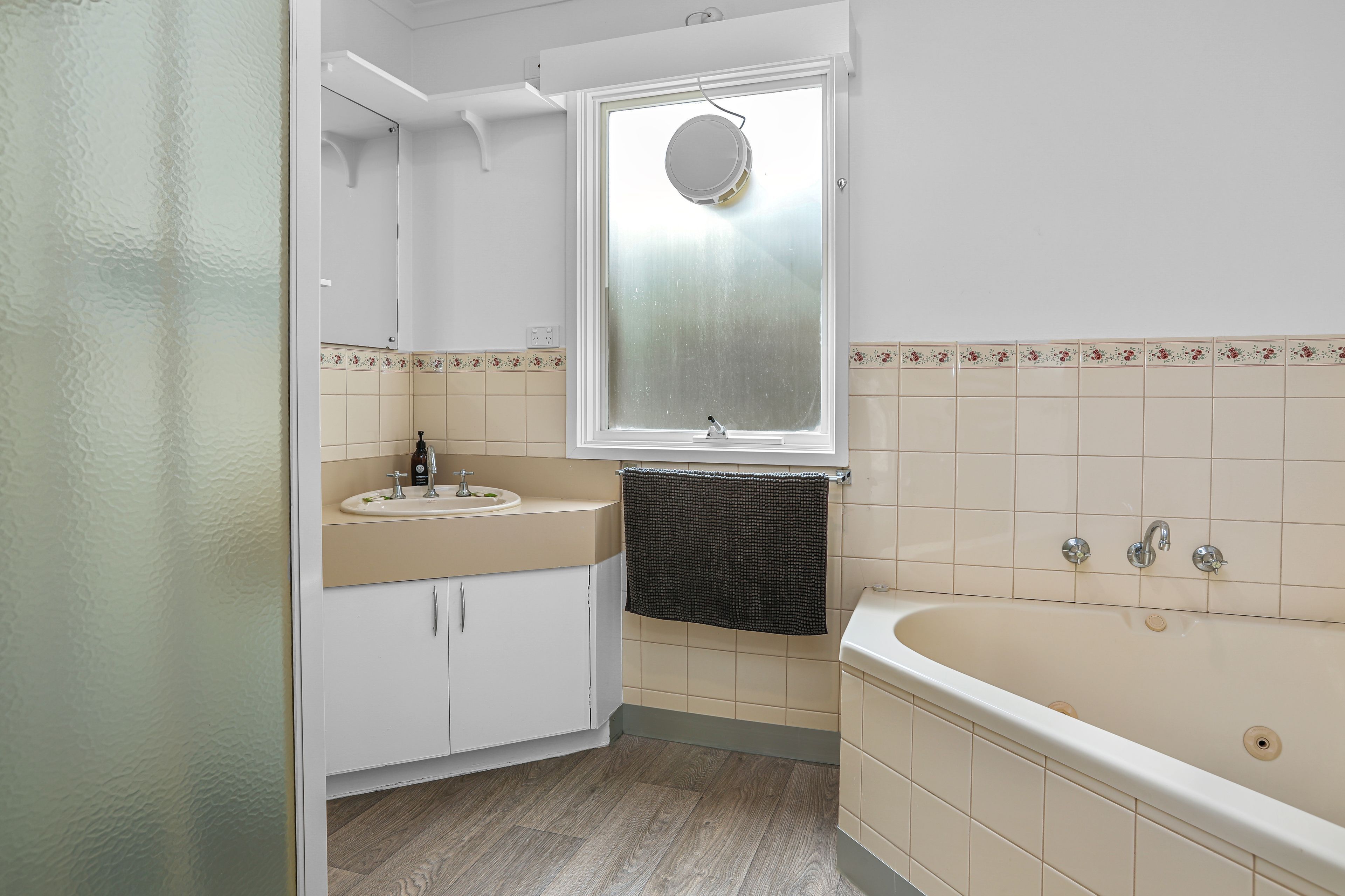 A bathroom with a bathtub, a sink, and a mirror.