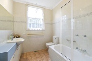 A bathroom with a toilet, sink, and bathtub.