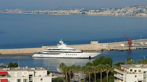Un grand yacht était amarré dans une marina, avec une vue sur la ville en arrière-plan.