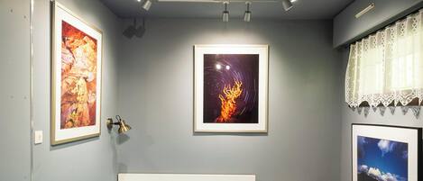 Un dormitorio con cama de 140x190 cm, cuadros de arte y vistas al cielo nocturno.
