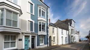 A row of traditional buildings with bay windows and a clear blue sky. - High House (6), Tenby , Pembrokeshire (Tenby)