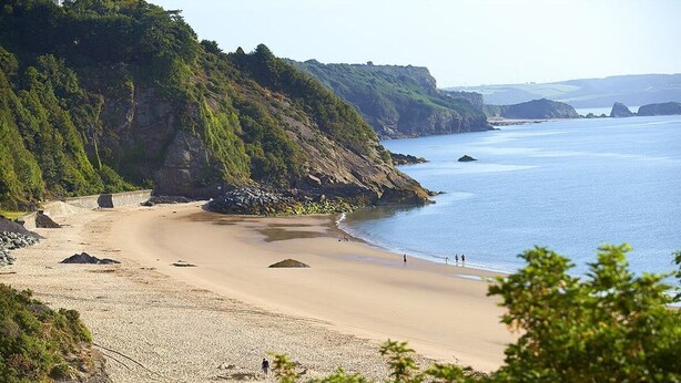 A beach with tents and rocky cliffs. - High House (6), Tenby , Pembrokeshire (Tenby)