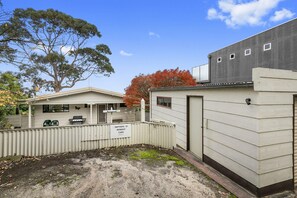 A residential area with a house, a garage, and a fenced yard.