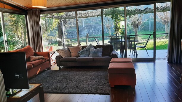 Un salón moderno con un amplio ventanal que da a un jardín.