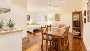 A compact living space with a dining area, a bed, and a kitchenette. - Casa Grande - Minho's Guest (Braga)