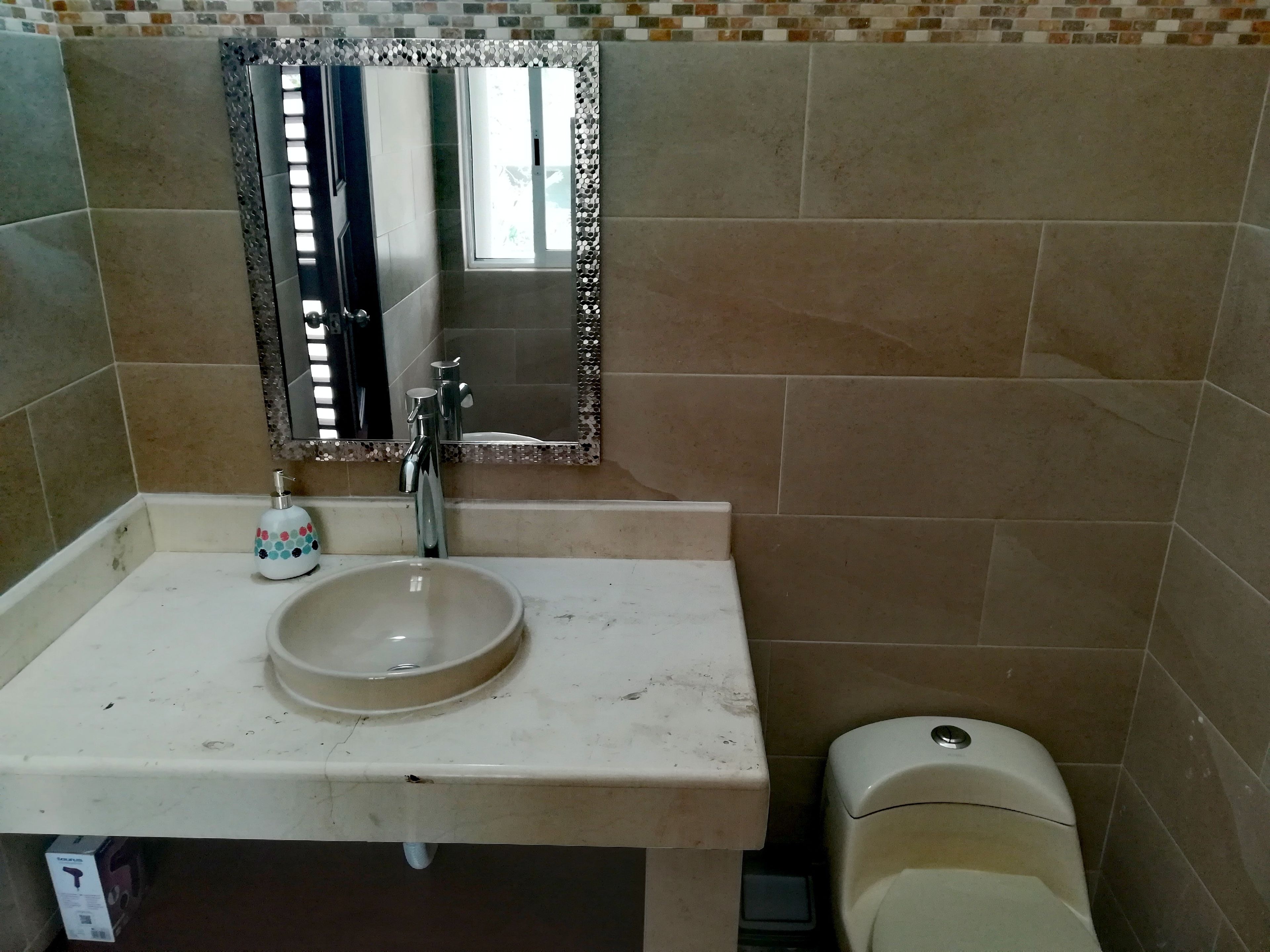 Ein Badezimmer mit Waschbecken, Spiegel und Toilette.