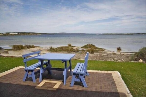 Enjoy a serene picnic by the water's edge, surrounded by lush greenery.