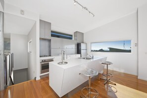 Eine moderne Küche mit Kochinsel, Edelstahlgeräten und einem großen Fenster mit Blick.