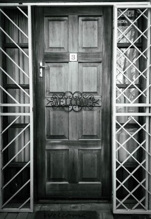 A wooden door with a number '3' and a 'WELCOME' sign, flanked by metal gates. - Padlangs (Kimberley)