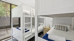 Quarto com beliche, mesa de cabeceira e criadeira.