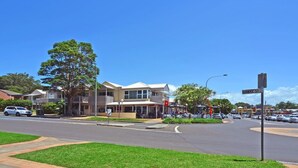 A street view with a two-story building, a clear sky, and a sign for Hawke St.