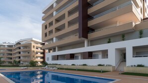 A modern multi-story residential building with a swimming pool, balconies, and a well-maintained garden area. - Harris Apartment, Pool, Wifi (Lagos)