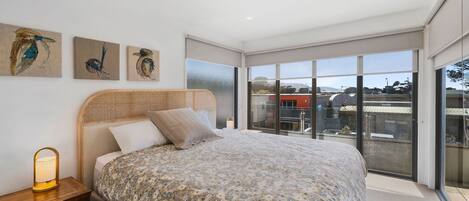 Une chambre à coucher avec un grand lit, une table de chevet et des œuvres d’art murales.