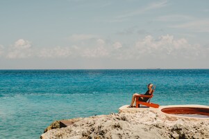 Praia particular, areia branca, espreguiçadeiras, guarda-sóis 