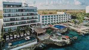 Un hôtel doté de nombreux balcons, d’une piscine et offrant une vue sur l’océan.