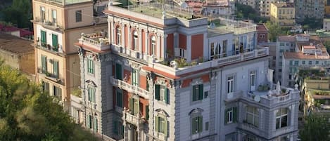 A multi-story building with balconies, a courtyard, and a street view.