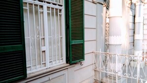 A building facade with green shutters, a white metal gate, and a red brick entrance. - L'Atelier | Vedi Napoli ai tuoi piedi  (Napoli)