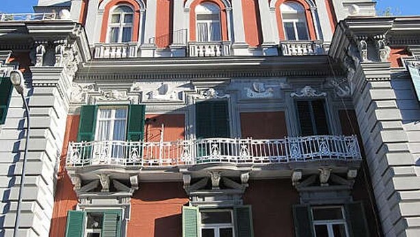 A building with a balcony, ornate architectural details, and a clear blue sky. - L'Atelier | Vedi Napoli ai tuoi piedi  (Napoli)