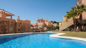 A swimming pool surrounded by buildings with a clear blue sky. - ⭐ DREAM SEA VIEW PENTHOUSE - LUXURIOUS 3 BEDROOMS ⭐ (Calahonda)