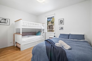 Ein Schlafzimmer mit einem Etagenbett, einem Einzelbett und einem Fenster mit Blick.