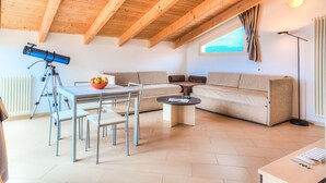 A cozy living room with a telescope, a bowl of fruit, a sofa, and a coffee table. - ViP Panorama, in villa with heated pool (Diano Marina)