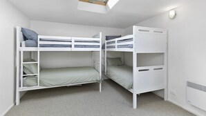 A room with bunk beds, a skylight, and a wall-mounted light fixture. - Lorne Lodge (Lorne)