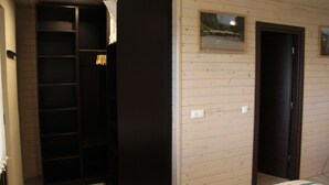 A bedroom with a bed, a wardrobe, and a door.
